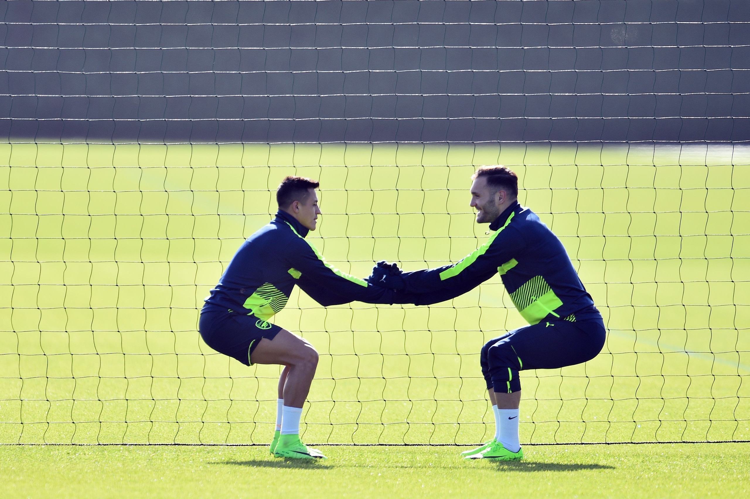 Arsenal's Chilean striker Alexis Sanchez (L) and Arsenal's Spanish striker Lucas Perez are seen during a training session ahead of their UEFA Champions League round of 16 second leg football match against Bayern Munich at Arsenal's London Colney training 