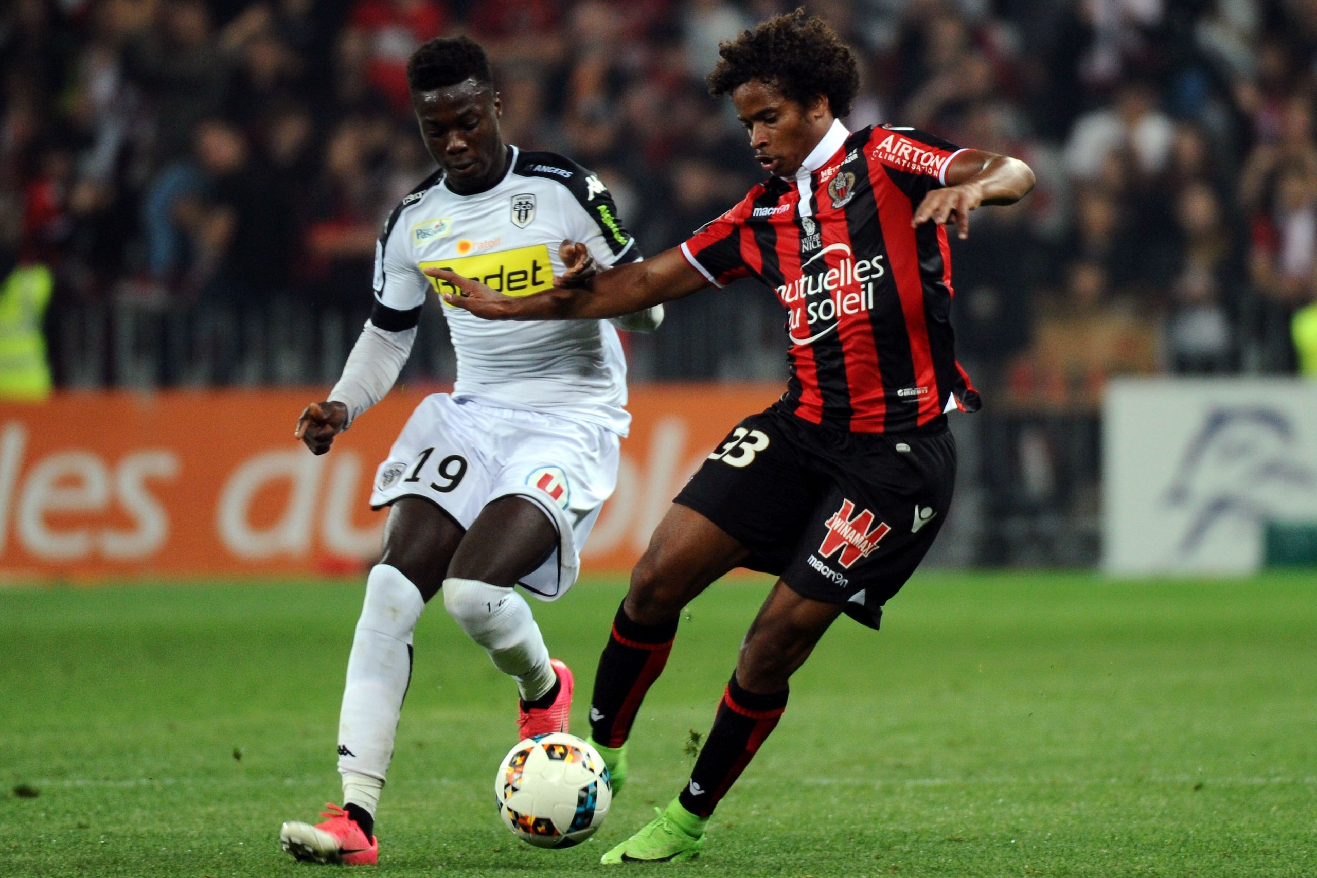 Nices French midfielder Vincent Marcel (R) vies with Angers' French forward Nicolas Pepe during the French L1 football match between Nice and Angers, on May 14, 2017, at the Allianz Riviera stadium in Nice, southeastern France. / AFP PHOTO / Franck PENNAN