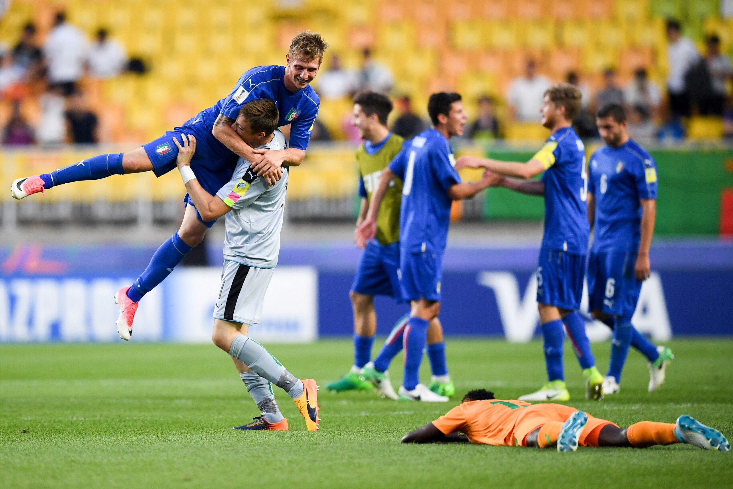 Italy's goalkeeper Andrea Zaccagno lifts up forward Luca Vido as they celebrate their victory during the U-20 World Cup quarter-final football match between Italy and Zambia in Suwon on June 5, 2017.  / AFP PHOTO / JUNG Yeon-Je        (Photo credit should