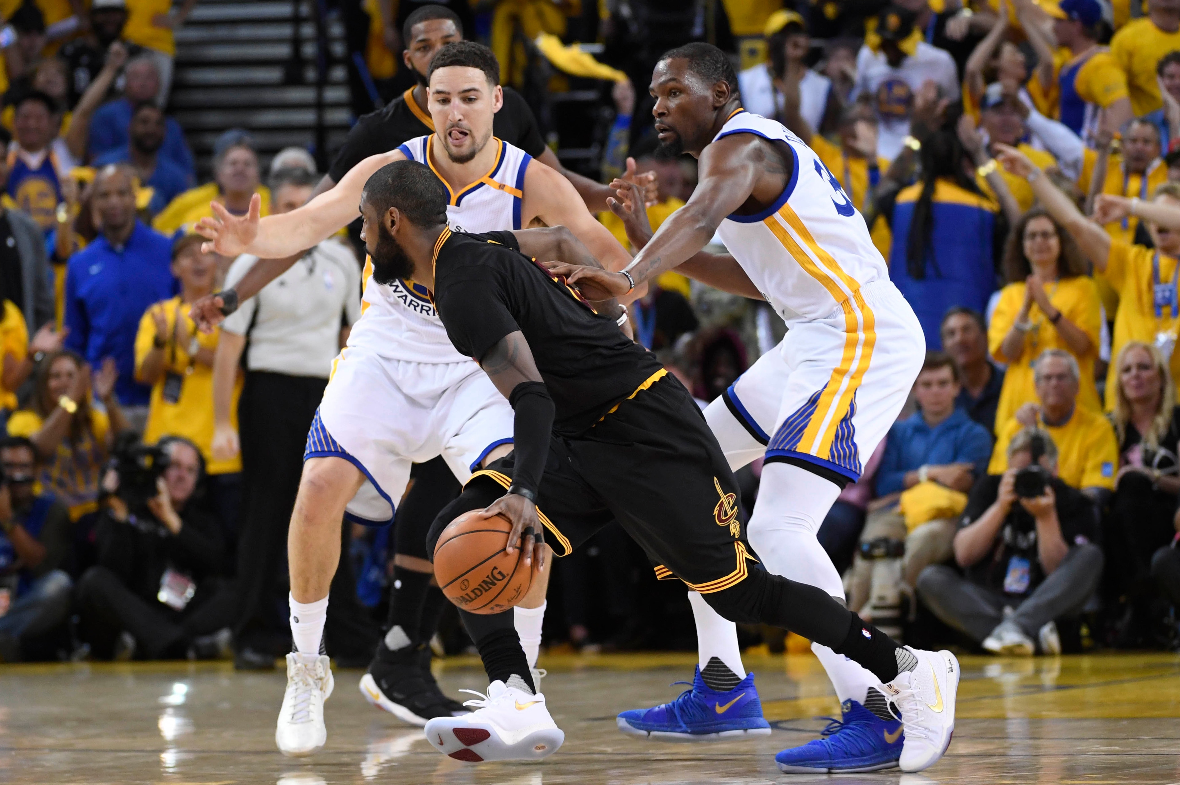 Jun 4, 2017; Oakland, CA, USA; Cleveland Cavaliers guard Kyrie Irving (2) dribbles the ball against Golden State Warriors guard Klay Thompson (11) and forward Kevin Durant (35) during the second half in game two of the 2017 NBA Finals at Oracle Arena. Man