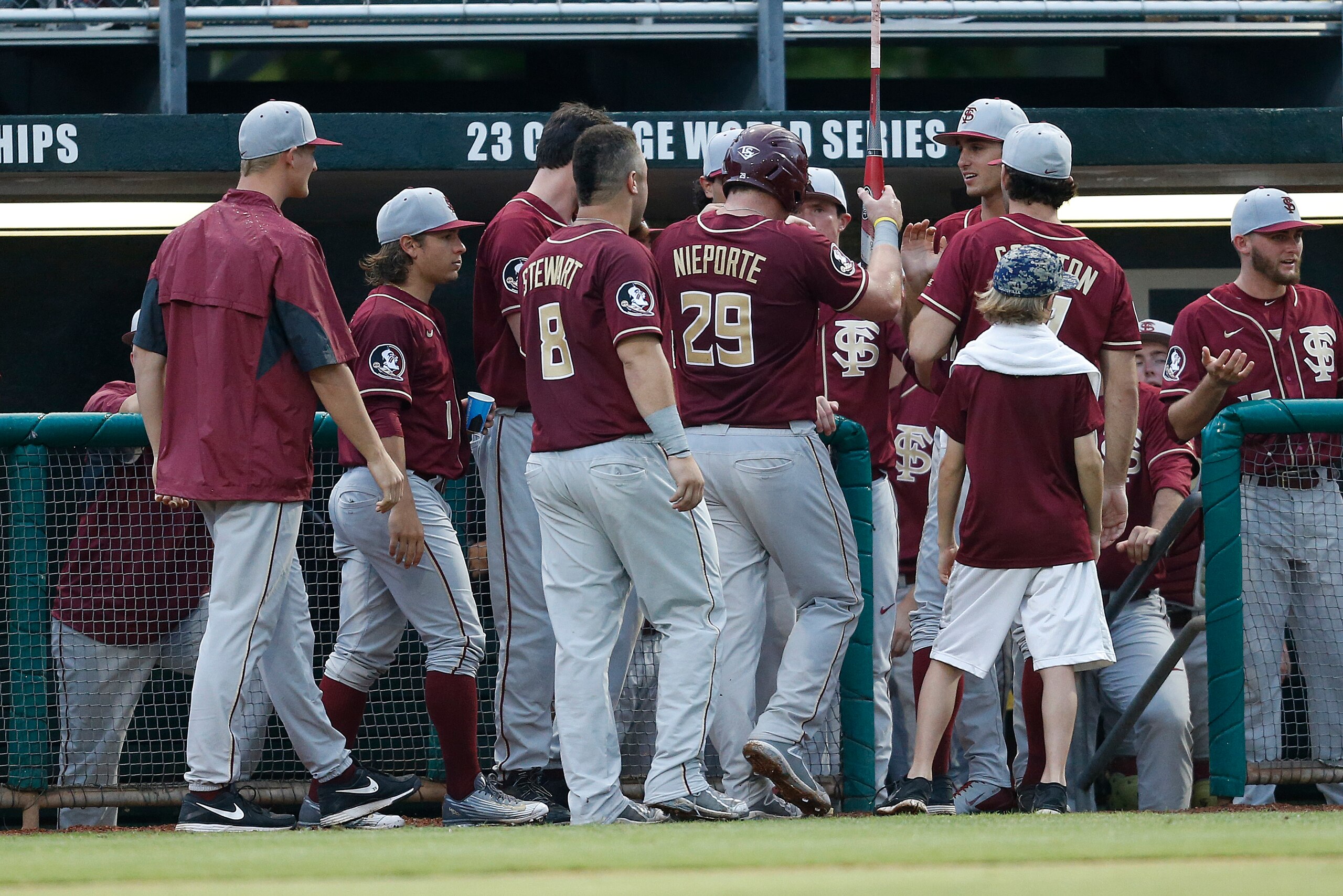 CORAL GABLES, FL - APRIL 24: Quincy Nieporte #29 is congratulated by teammates after scoring on a hit by Dylan Busby #28 (not pictured) of the Florida State Seminoles against the Miami Hurricanes on April 24, 2015 at Alex Rodriguez Park at Mark Light Fiel