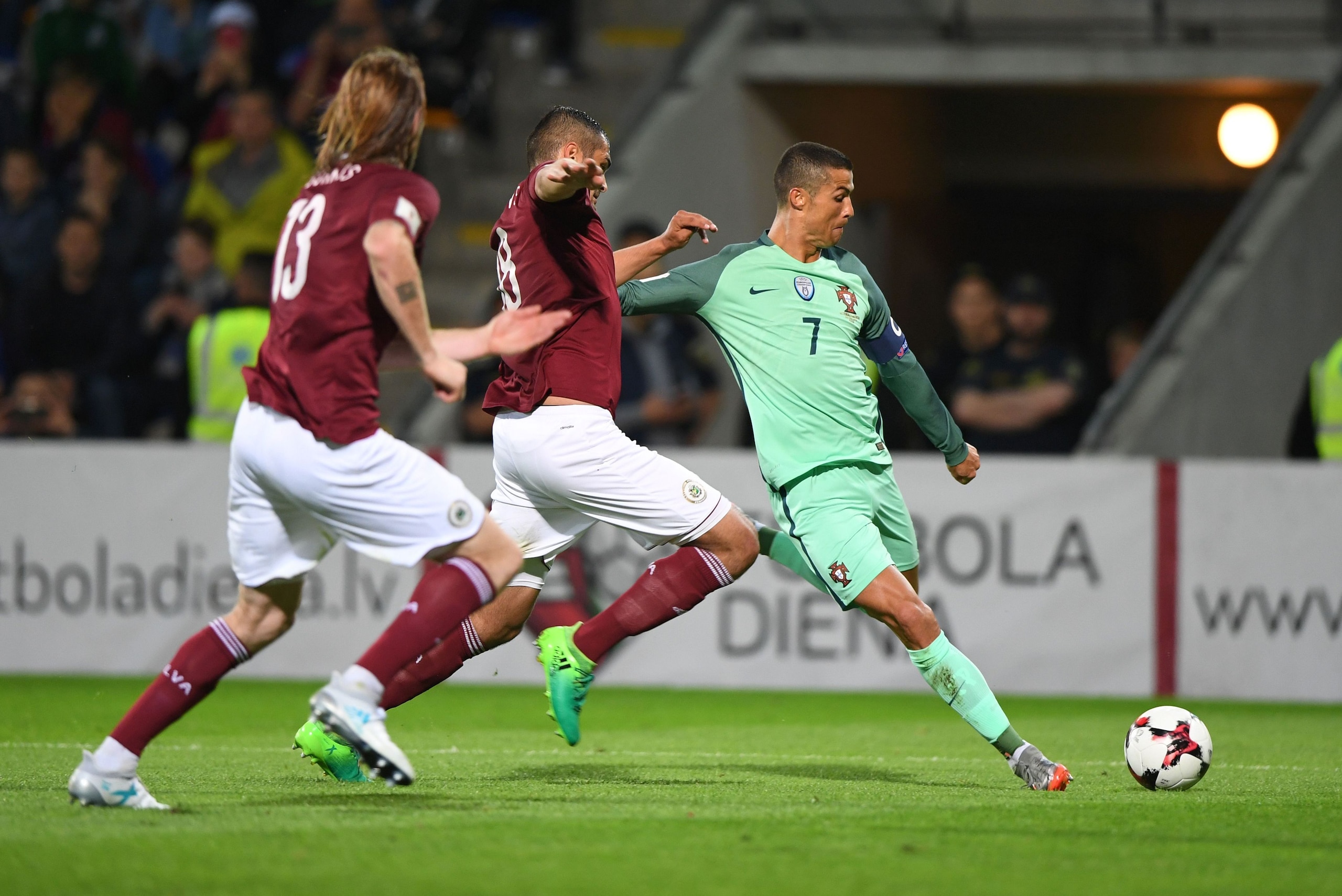 Latvia's Nikita Kolesovs and Portugal's forward Cristiano Ronaldo (R) vie for the ball during the FIFA World Cup 2018 qualification football match between Latvia and Portugal in Riga, on June 9, 2017. / AFP PHOTO / JANEK SKARZYNSKI        (Photo credit sh