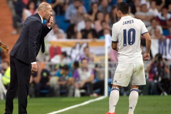 Real Madrid's French coach Zinedine Zidane (L) talks with Real Madrid's Colombian midfielder James Rodriguez during the Spanish league football match Real Madrid CF vs Villarreal CF at the Santiago Bernabeu stadium in Madrid on September 21, 2016. / AFP /