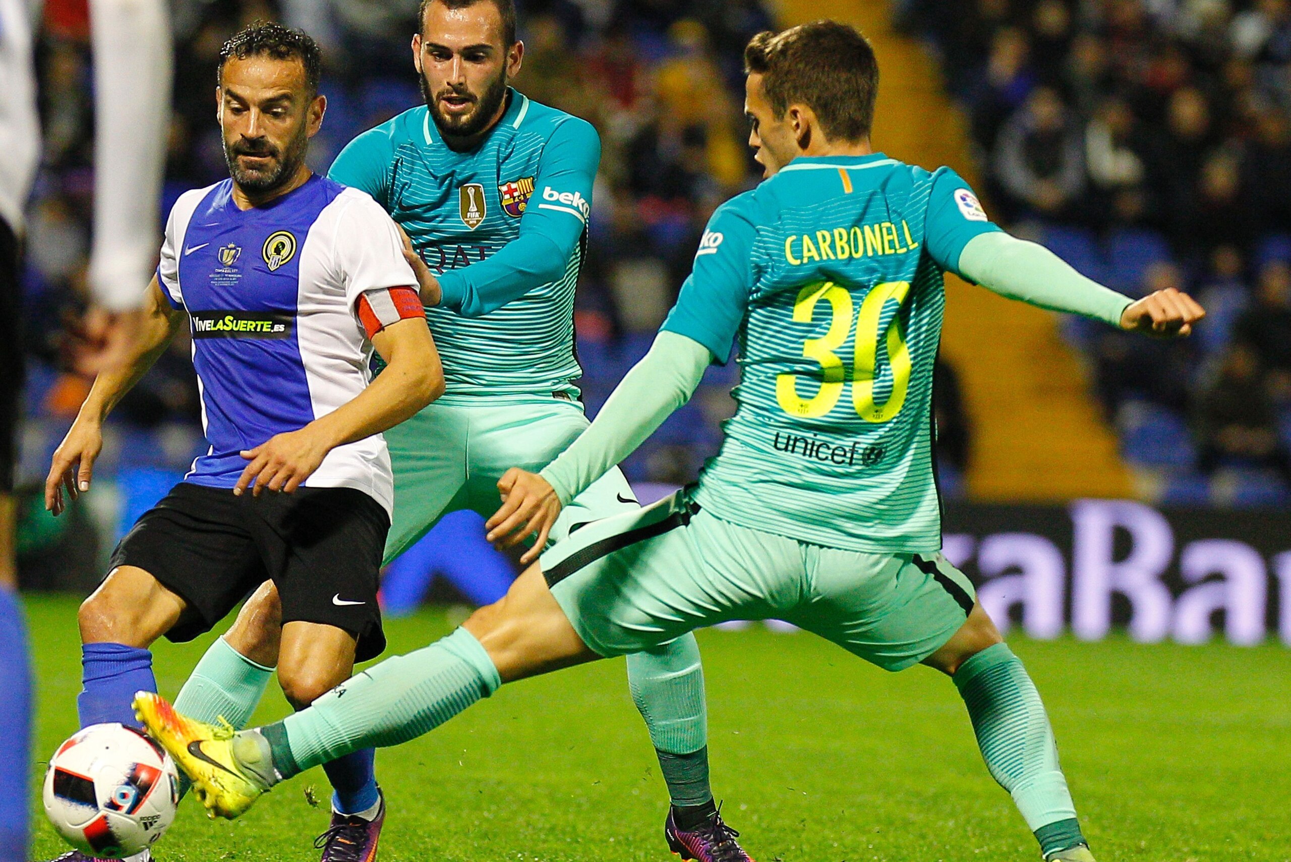 Hercules' defender Francisco Pena  (L) vies with Barcelona's defender Aleix Vidal (C) and Barcelona's forward Alex Carbonell during the Spanish Copa del Rey (King's Cup) round of 32 first leg football match Hercules CF vs FC Barcelona at the Estadio Jose 