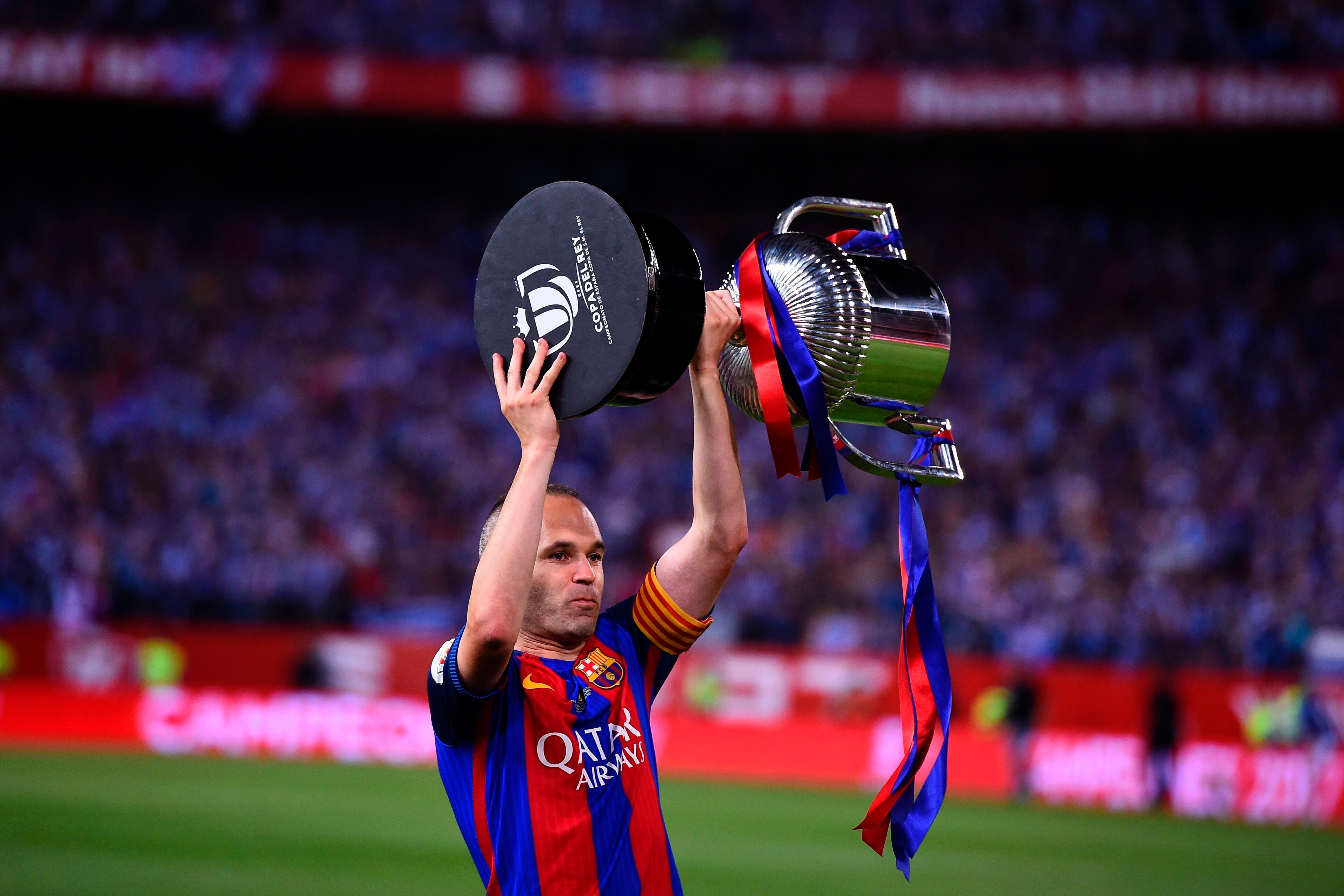 Barcelona's midfielder Andres Iniesta holds up the cup after the team won the Spanish Copa del Rey (King's Cup) final football match FC Barcelona vs Deportivo Alaves at the Vicente Calderon stadium in Madrid on May 27, 2017.
Barcelona won 3-1. / AFP PHOTO