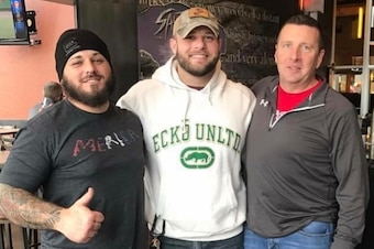 Jimi Long (left) gives a thumb-up sign while hanging out recently with two friends.