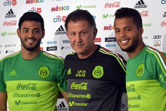Mexico's national football team players Carlos Vela (L) and Giovani dos Santos (R) and coach Juan Carlos Osorio pose for photos during a press conference before a training session ahead of the World Cup qualifier against Honduras and the United States at 