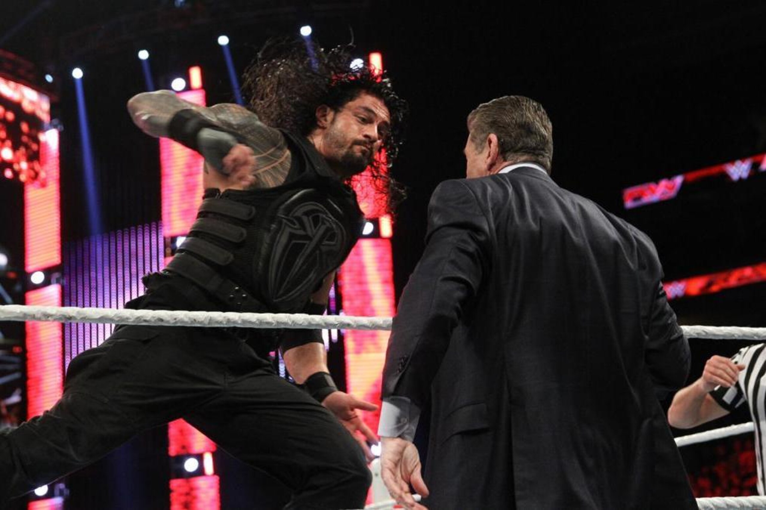 Roman Reigns hits Vince McMahon with a Superman Punch. Roman Reigns hits Vince McMahon with a Superman Punch.