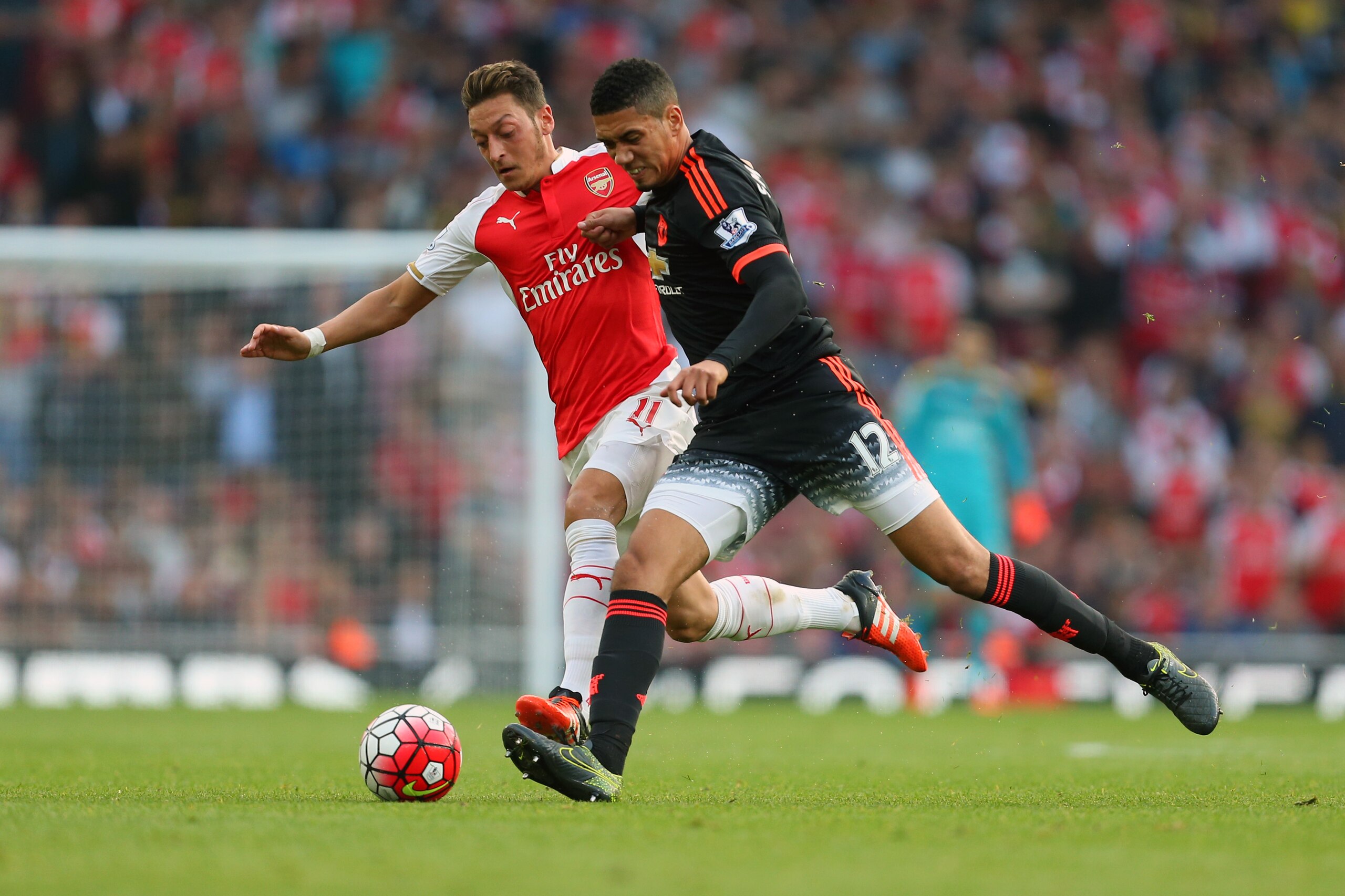 LONDON, ENGLAND - OCTOBER 04:  Mesut Ozil of Arsenal and Chris Smalling of Manchester United during the Barclays Premier League match between Arsenal and Manchester United at the Emirates Stadium on October 04, 2015 in London, United Kingdom.  (Photo by C