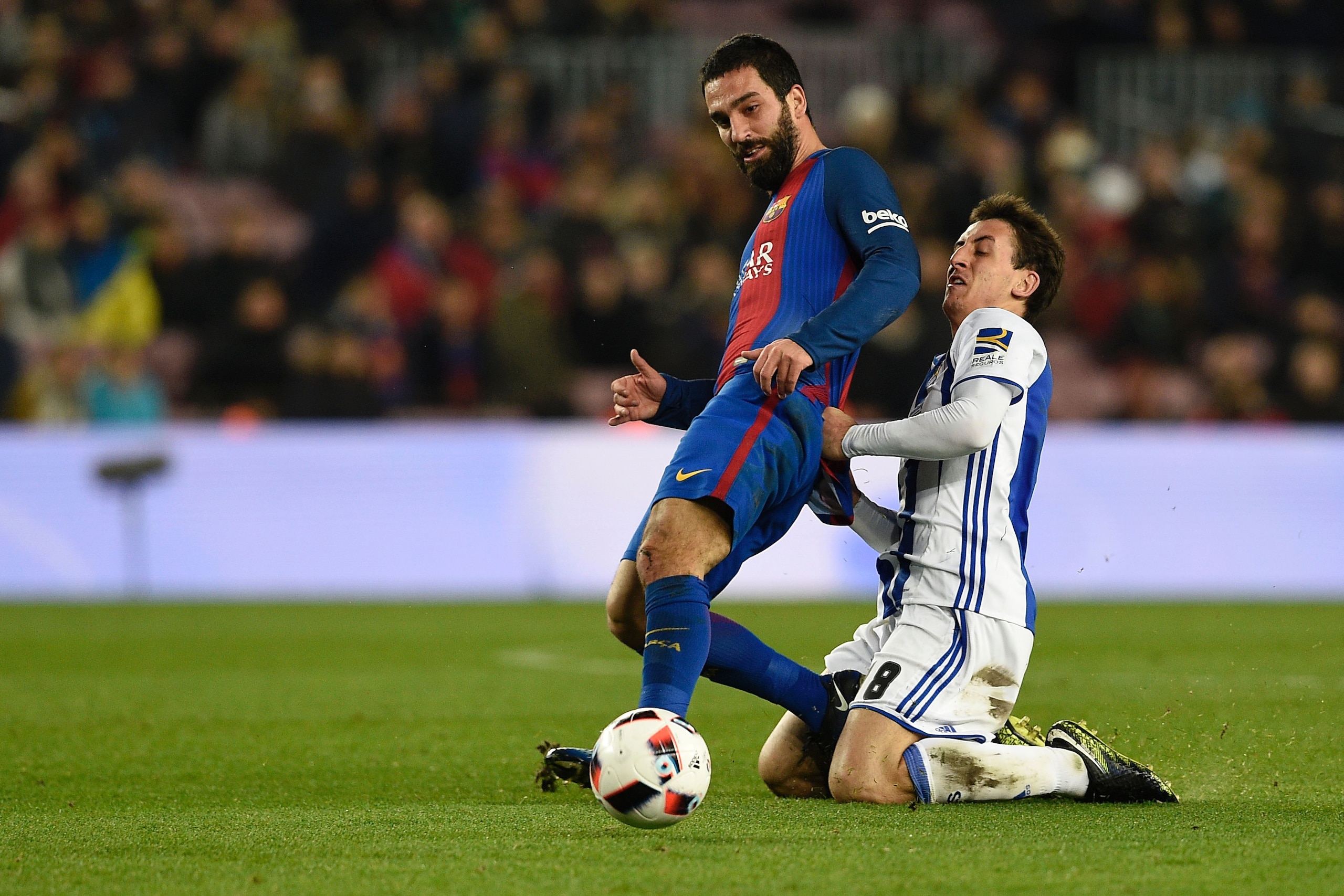 Barcelona's Turkish forward Arda Turan (L) vies with Real Sociedad's midfielder Esteban Granero during the Spanish Copa del Rey (King's Cup) quarter final second leg football match FC Barcelona vs Real Sociedad at the Camp Nou stadium in Barcelona on Janu