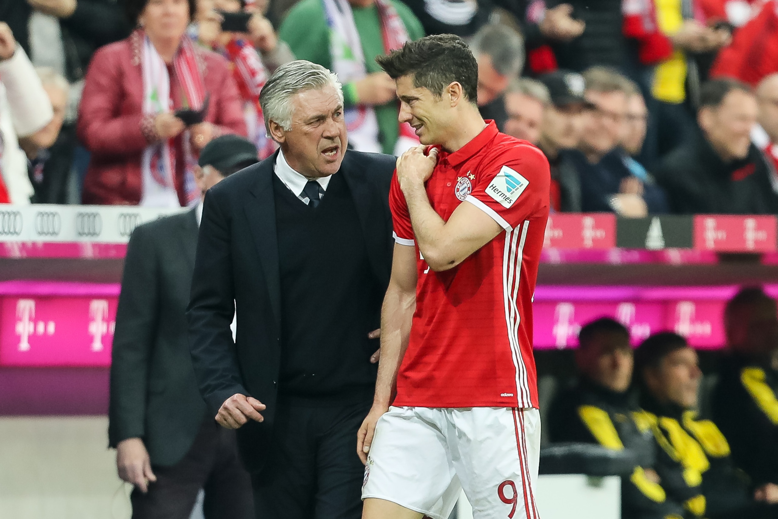 MUNICH, GERMANY - APRIL 08: Robert Lewandowski of Bayern Muenchen feels tha pain while being congratulated by Carlo Ancelotti head coach of Bayern Muenchen after being substituted during the Bundesliga match between Bayern Muenchen and Borussia Dortmund a