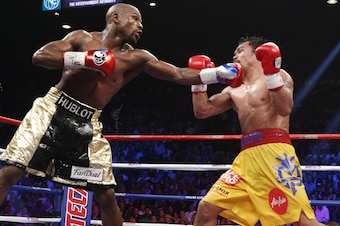 Floyd Mayweather Jr. exchange punches with Manny Pacquiao during their welterweight unification championship bout, May 2, 2015 at MGM Grand Garden Arena in Las Vegas, Nevada.  Mayweather defeated Pacquiao by unanimous decision.  AFP PHOTO / JOHN GURZINKSI