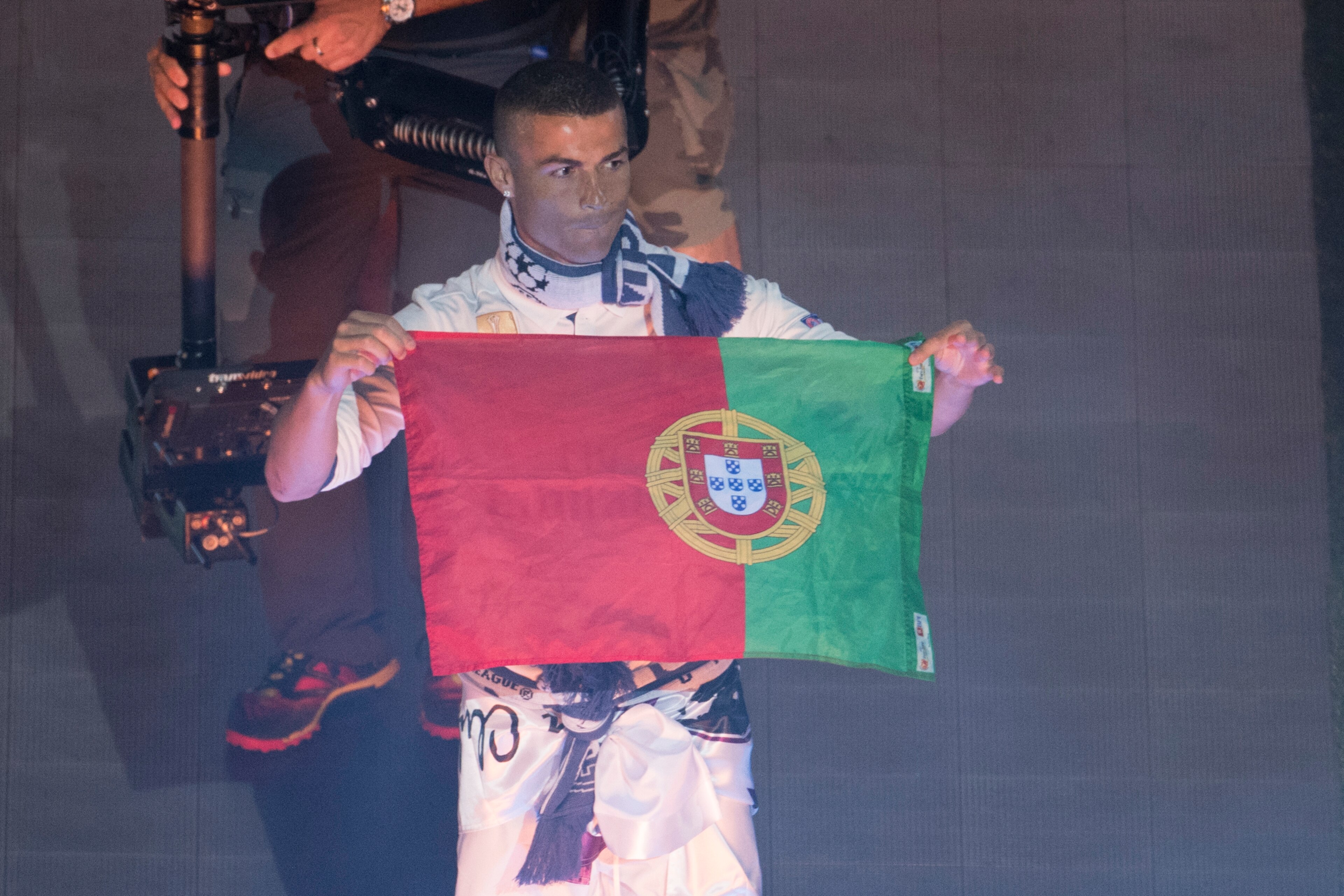 Real Madrid's Portuguese forward Cristiano Ronaldo holds up a Prtugeuse flag during a celebration event held at the Santiago Bernabeu stadium after the team won the the UEFA Champions League football match final Juventus vs Real Madrid CF held at the Nati