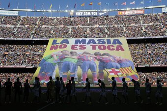 Barcelona's supporters unveil a giant banner reading in Catalan 'La Masia, don't touch it' before the Spanish league football match FC Barcelona vs Real Betis at the Camp Nou stadium in Barcelona.  AFP PHOTO / JOSEP LAGO        (Photo credit should read J