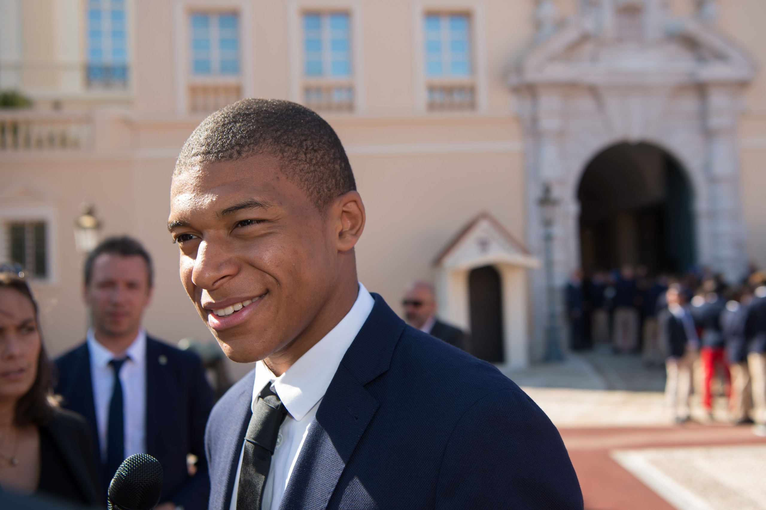 Monaco's French forward Kylian Mbappe speaks to journalists as hes arrives at the Prince's Palace in Monaco on May 21, 2017, to attend celebrations to mark the club winning their first French Ligue 1 title in 17 years. / AFP PHOTO / BERTRAND LANGLOIS     
