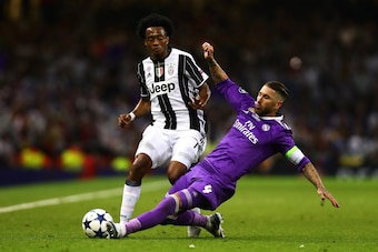 CARDIFF, WALES - JUNE 03: Juan Cuadrado of Juventus in action with Sergio Ramos of Real Madrid during the UEFA Champions League Final match between Juventus and Real Madrid at the National Stadium of Wales on June 3, 2017 in Cardiff, Wales. (Photo by Chri