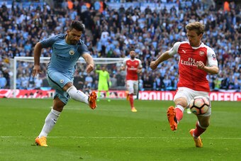 Manchester City's Argentinian striker Sergio Aguero (L) attempts a shot at goal past Arsenal's Spanish defender Nacho Monreal during the FA Cup semi-final football match between Arsenal and Manchester City at Wembley stadium in London on April 23, 2017. /