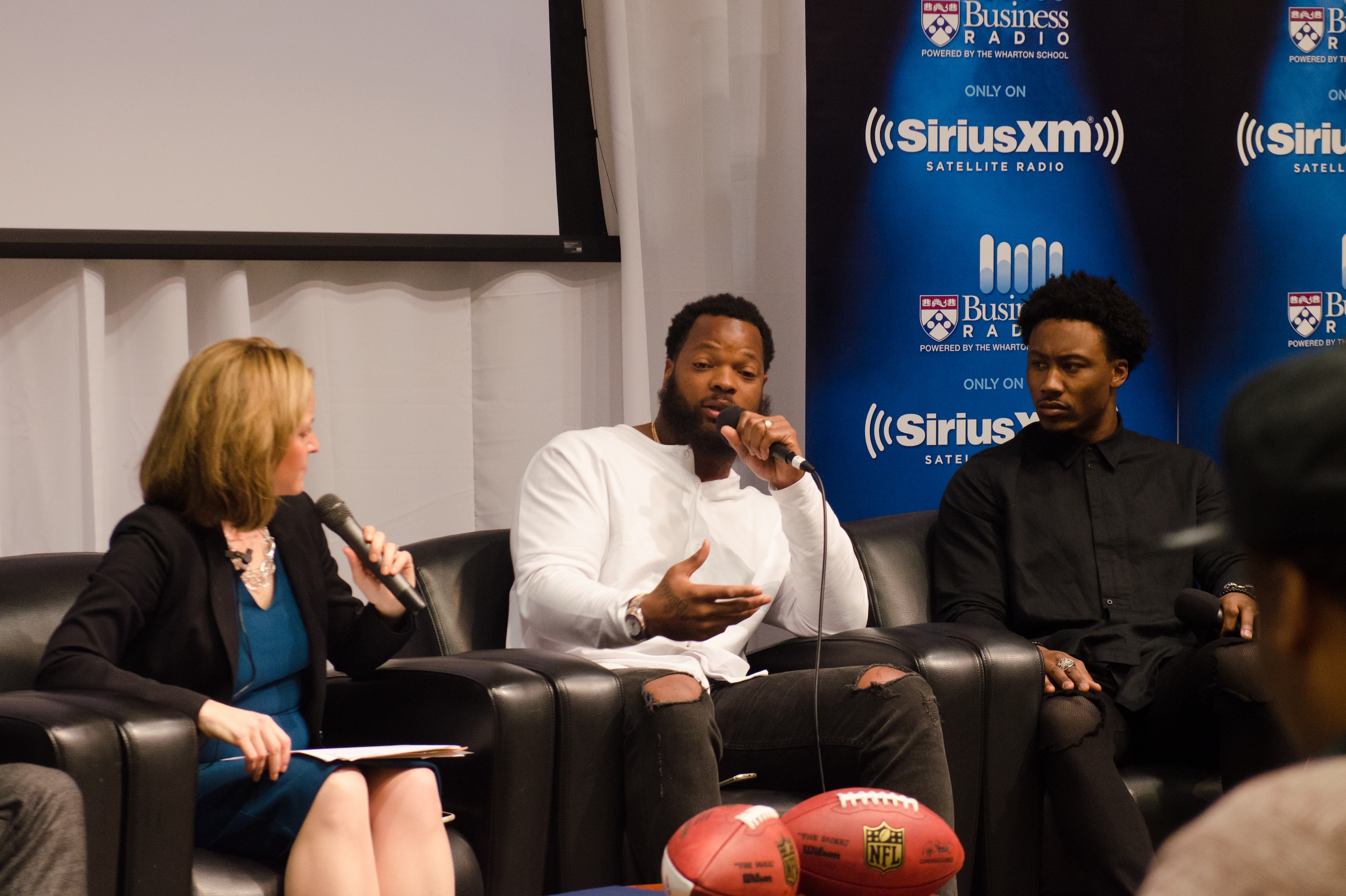 Dr. Jocelyn Benson, Michael Bennett and Brandon Marshall at a RISE event during Super Bowl week.