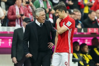 MUNICH, GERMANY - APRIL 08: Robert Lewandowski of Bayern Muenchen feels tha pain while being congratulated by Carlo Ancelotti head coach of Bayern Muenchen after being substituted during the Bundesliga match between Bayern Muenchen and Borussia Dortmund a