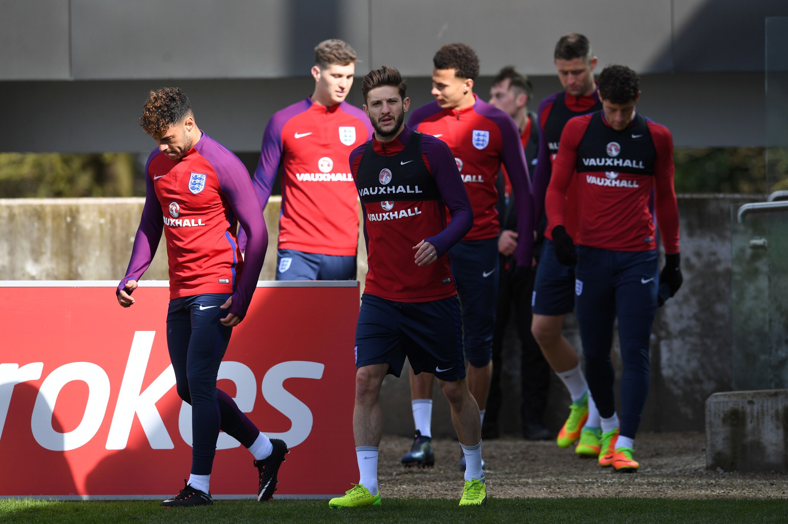 England's midfielder Alex Oxlade-Chamberlain (L) and England's midfielder Adam Lallana (C) arrive for a team training session at St George's Park in Burton-on-Trent on March 21, 2017, ahead of their friendly international football match against Germany in