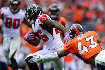 DENVER, CO - OCTOBER 9:  Running back Tevin Coleman #26 of the Atlanta Falcons breaks a tackle attempt by strong safety T.J. Ward #43 of the Denver Broncos for a touchdown in the third quarter of the game at Sports Authority Field at Mile High on October 