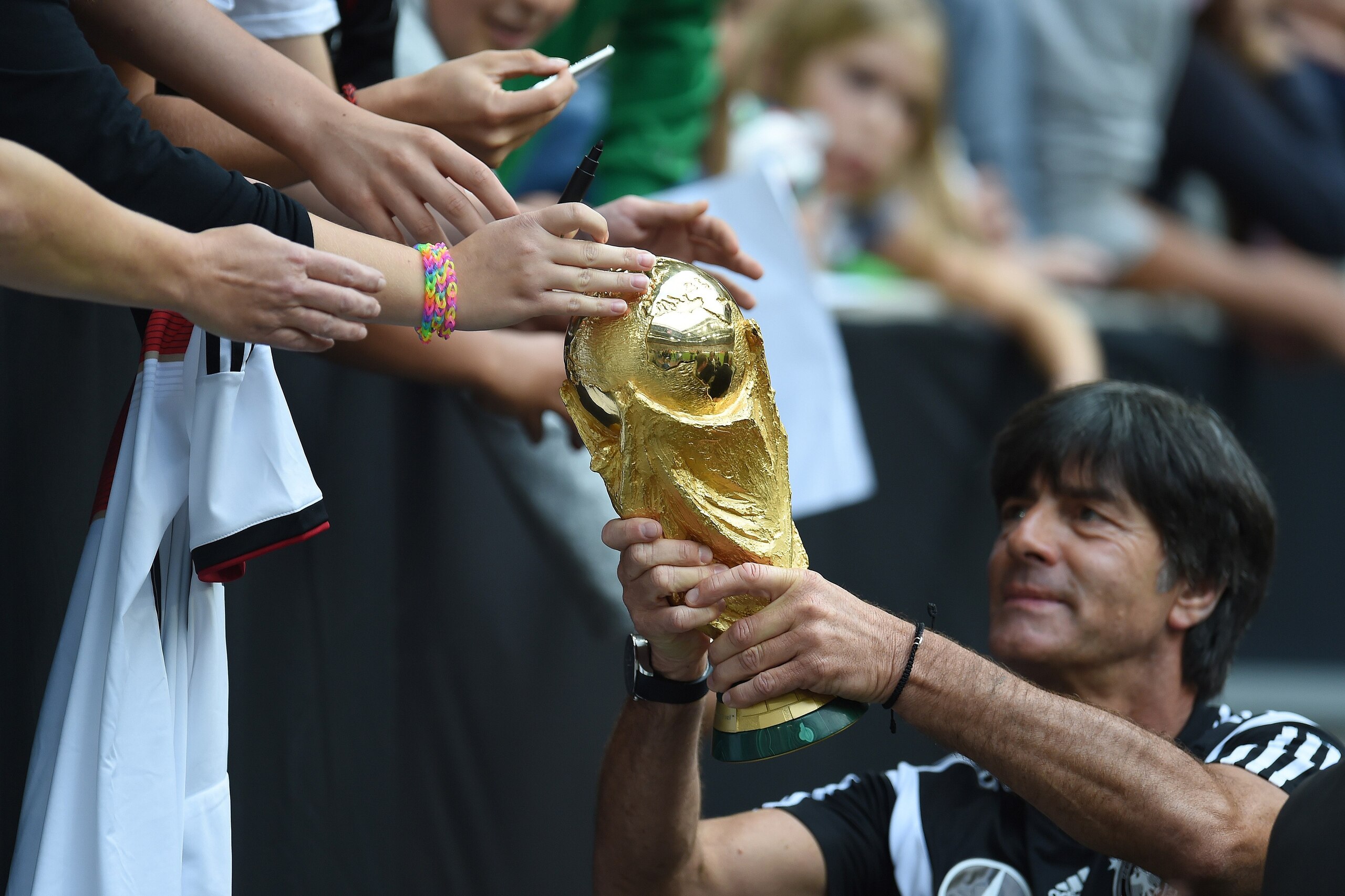 Germany's head coach Joachim Loew shows the world cup trophy to fans during a public training session of the German national football team in Duesseldorf, Germany on September 1, 2014. Germany's squad prepares for the upcoming friendly game against Argent