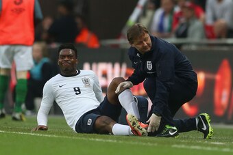 LONDON, ENGLAND - MAY 29:  An injured Daniel Sturridge of England is given treatment by physio Gary Lewin during the International Friendly match between England and the Republic of Ireland at Wembley Stadium on May 29, 2013 in London, England.  (Photo by