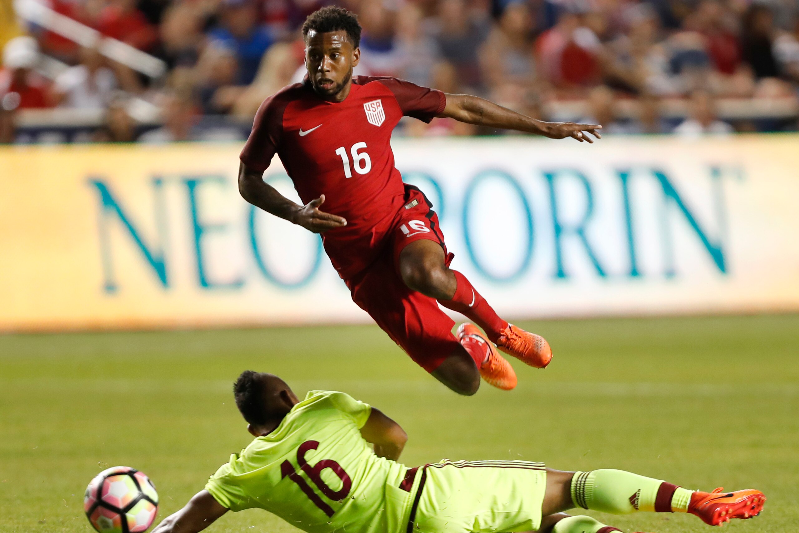 SANDY, UT - JUNE 3: United States midfielder Kellyn Acosta (T) jumps over Venezuela's midfielder AristÃ³teles Romero (B) as he goes for the ball during the second half of an international friendly soccer game on June 3, 2017 at Rio Tinto Stadium in Sandy,