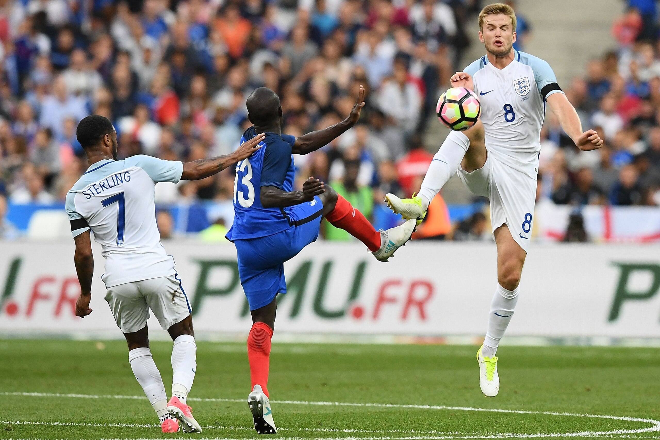 England's midfielder Eric Dier (R) and England's midfielder Raheem Sterling (L) fight for the ball with France's defender N'golo Kante (C) during the international friendly football match between France and England at The Stade de France Stadium in Saint-
