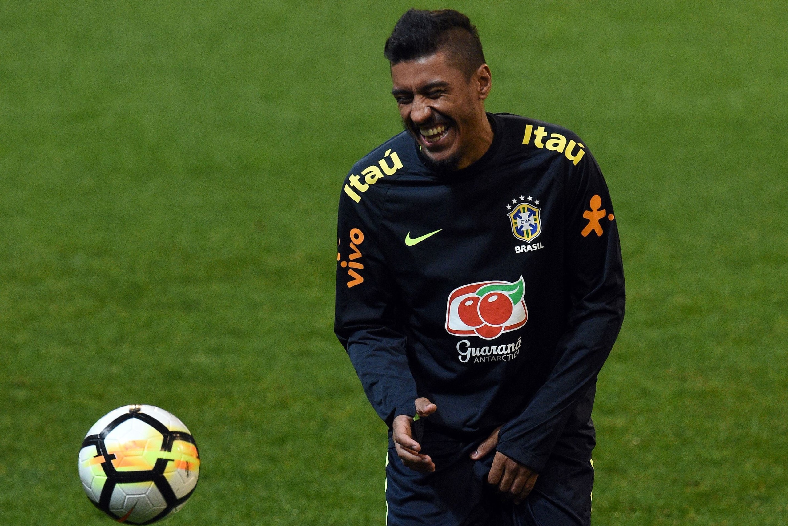 Brazil's player Paulinho laughs during a raining session with teammates in Melbourne on June 8, 2017, ahead of their football match against Brazil on June 9. / AFP PHOTO / SAEED KHAN / -- IMAGE RESTRICTED TO EDITORIAL USE - STRICTLY NO COMMERCIAL USE --  