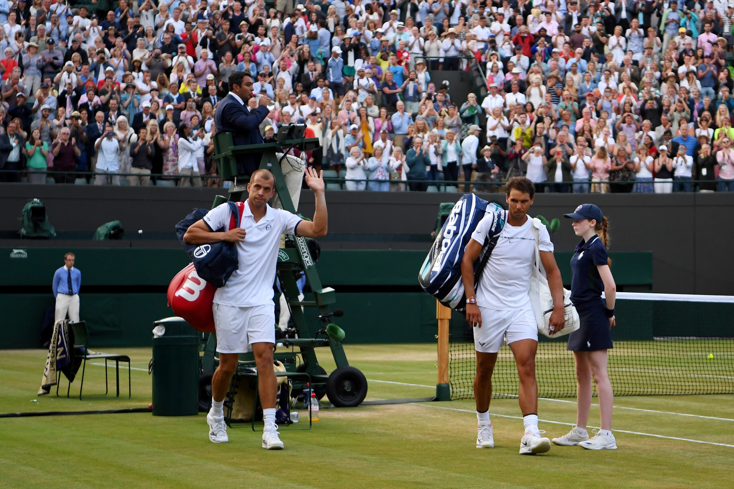 LONDON, ENGLAND - JULY 10:  Rafael Nadal of Spain looks dejected in defeat as Gilles Muller of Luxembourg acknowledges the crowd after the Gentlemen's Singles fourth round match against on day seven of the Wimbledon Lawn Tennis Championships at the All En