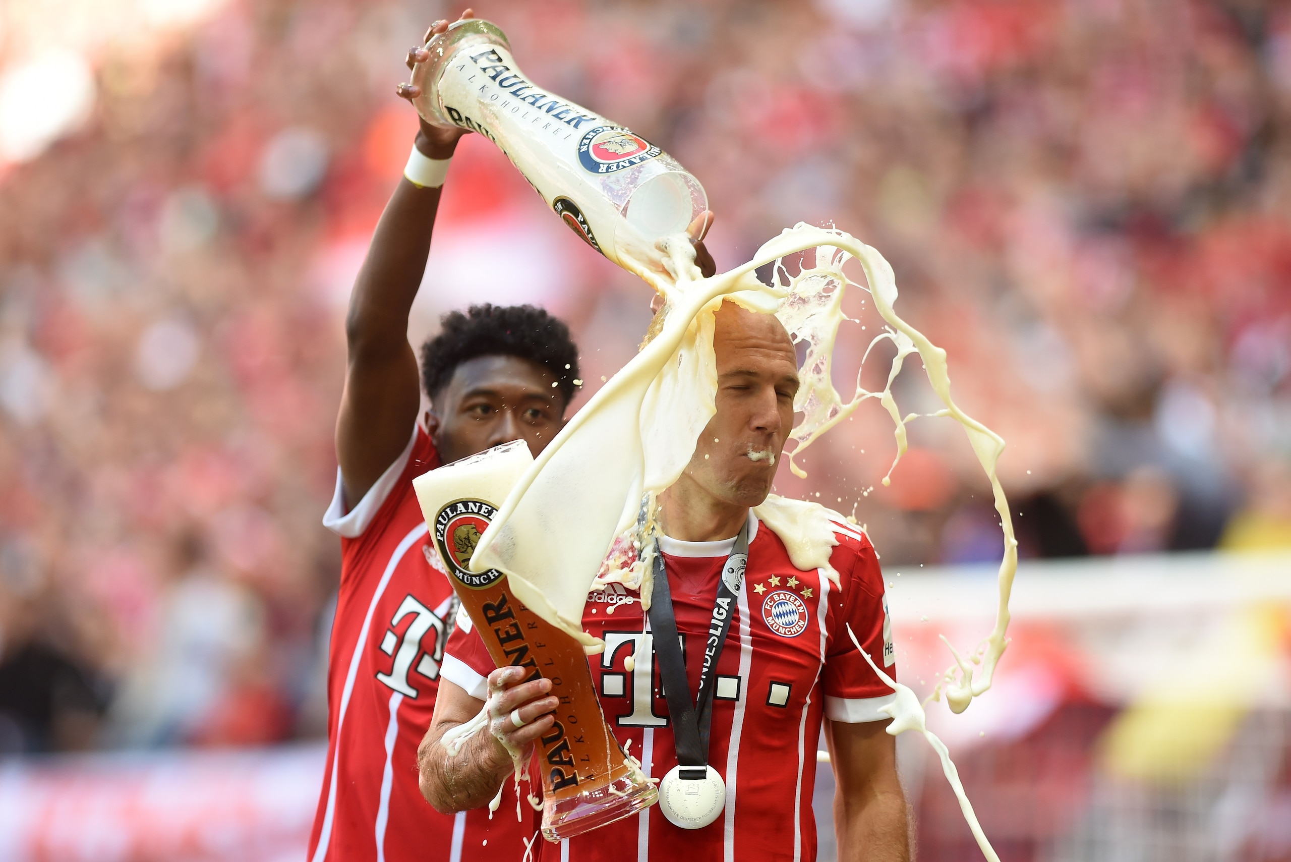 Bayern Munich's Austrian defender David Alaba (L) pours beer over Bayern Munich's Dutch midfielder Arjen Robben after the German first division Bundesliga football match FC Bayern Munich vs SC Freiburg, his last match for the club, in the southern German 