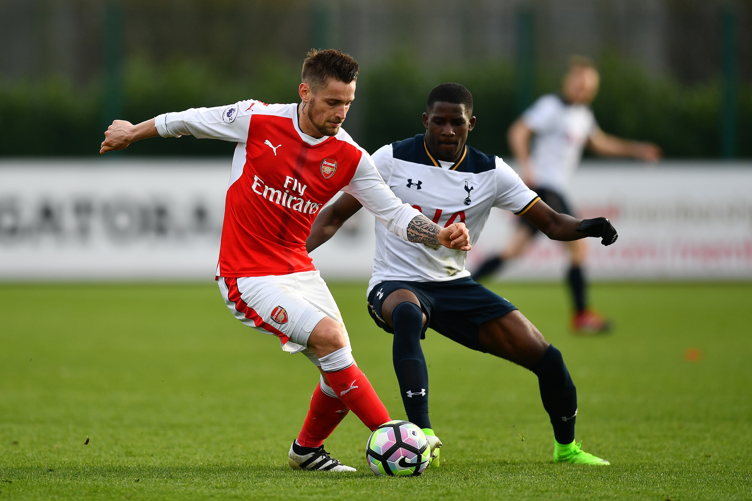 ST ALBANS, ENGLAND - MARCH 03:  Mathieu Debuchy of Arsenal holds off Shilow Tracey of Tottenham Hotspur during the Premier League 2 match between Arsenal and Tottenham Hotspur at London Colney on March 3, 2017 in St Albans, England. (Photo by Dan Mullan/G