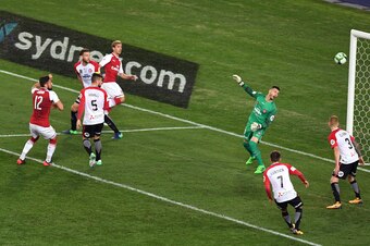 Arsenal player Olivier Giroud (2/L) shoots past Western Sydney Wanderers goalkeeper Vedran Janjetovic (3/R) in their pre-season football friendly played in Sydney on July 15, 2017. / AFP PHOTO / WILLIAM WEST / -- IMAGE RESTRICTED TO EDITORIAL USE - STRICT