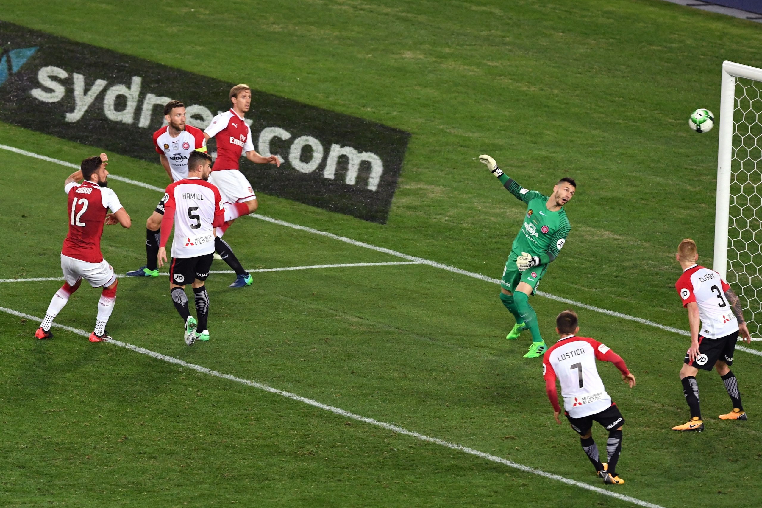 Arsenal player Olivier Giroud (2/L) shoots past Western Sydney Wanderers goalkeeper Vedran Janjetovic (3/R) in their pre-season football friendly played in Sydney on July 15, 2017. / AFP PHOTO / WILLIAM WEST / -- IMAGE RESTRICTED TO EDITORIAL USE - STRICT