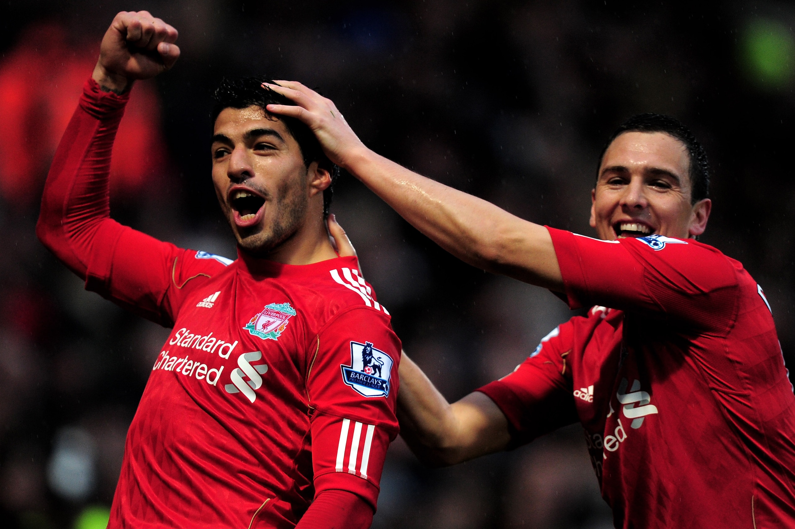 NORWICH, ENGLAND - APRIL 28:  (L-R) Luis Suarez of Liverpool is congratulated by teammate Stewart Downing after scoring his team's third goal and completing his hat trick during the Barclays Premier League match between Norwich City and Liverpool at Carro