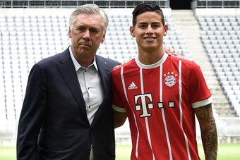 Colombian midfielder James Rodriguez, new recruit of German first division Bundesliga football club Bayern Munich, smiles as he poses with Bayern Munich's Italian headcoach Carlo Ancelotti (L) after the official presentation during a press conference for 