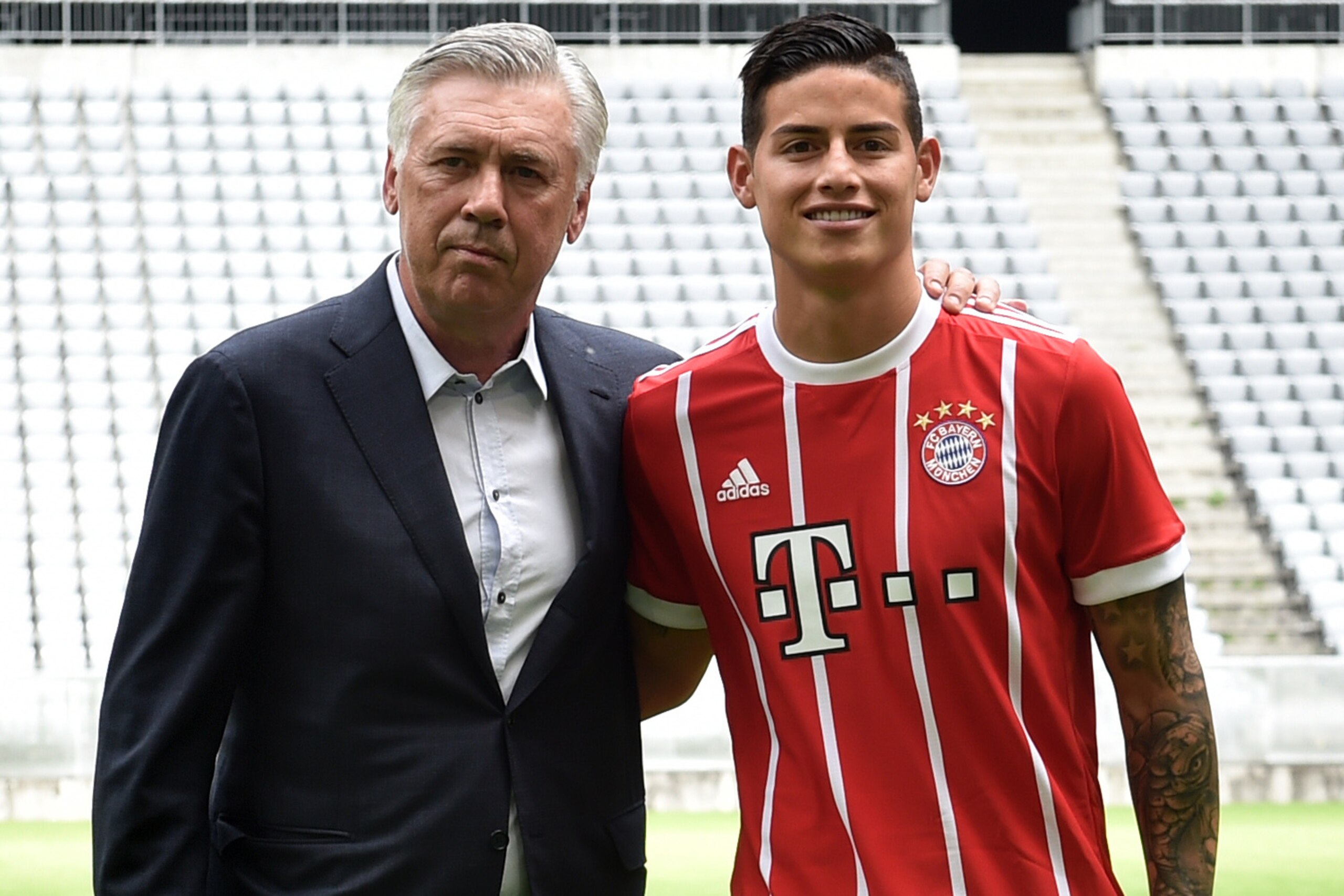 Colombian midfielder James Rodriguez, new recruit of German first division Bundesliga football club Bayern Munich, smiles as he poses with Bayern Munich's Italian headcoach Carlo Ancelotti (L) after the official presentation during a press conference for 