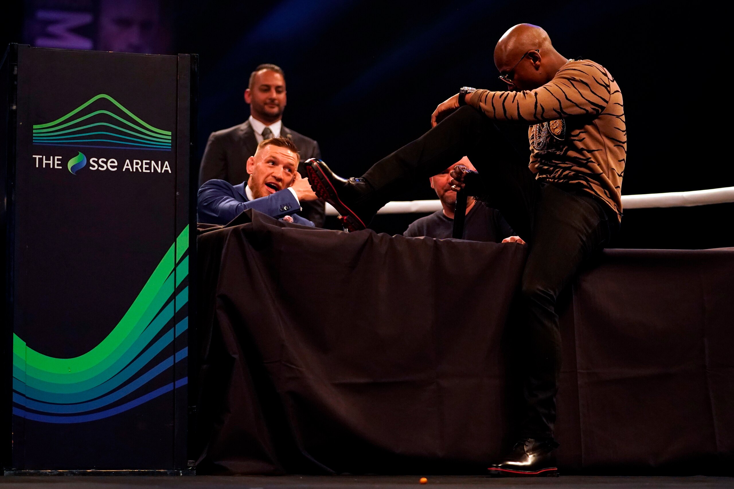 LONDON, ENGLAND - JULY 14:  (R-L) Floyd Mayweather Jr. sits on the table in front of Conor McGregor during the Floyd Mayweather Jr. v Conor McGregor World Press Tour event at SSE Arena on July 14, 2017 in London, England. (Photo by Jeff Bottari/Zuffa LLC/