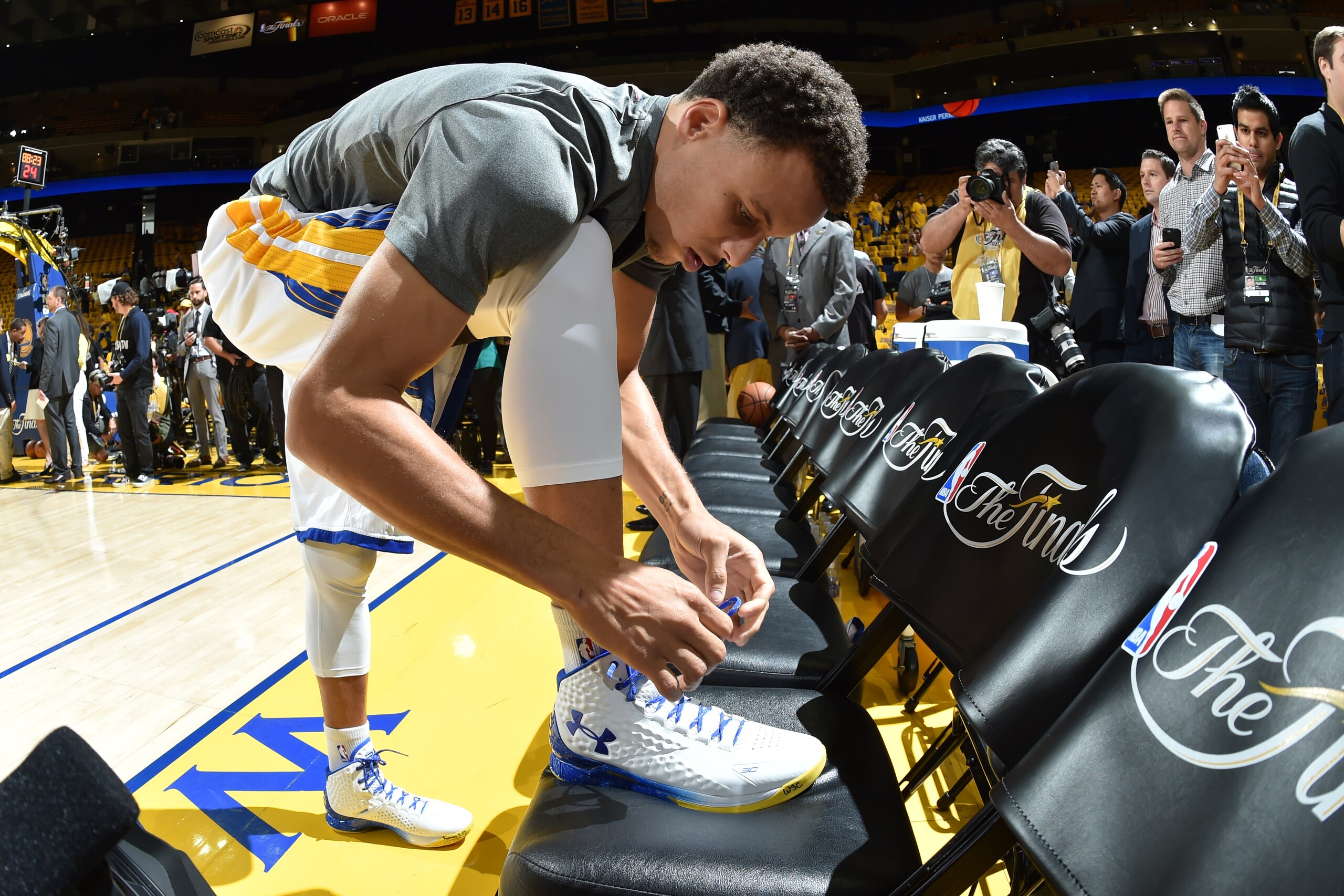 OAKLAND, CA - JUNE 14: Stephen Curry #30 of the Golden State Warriors ties his sneakers before Game Five of the 2015 NBA Finals at Oracle Arena on June 14, 2015 in Oakland, California. NOTE TO USER: User expressly acknowledges and agrees that, by download