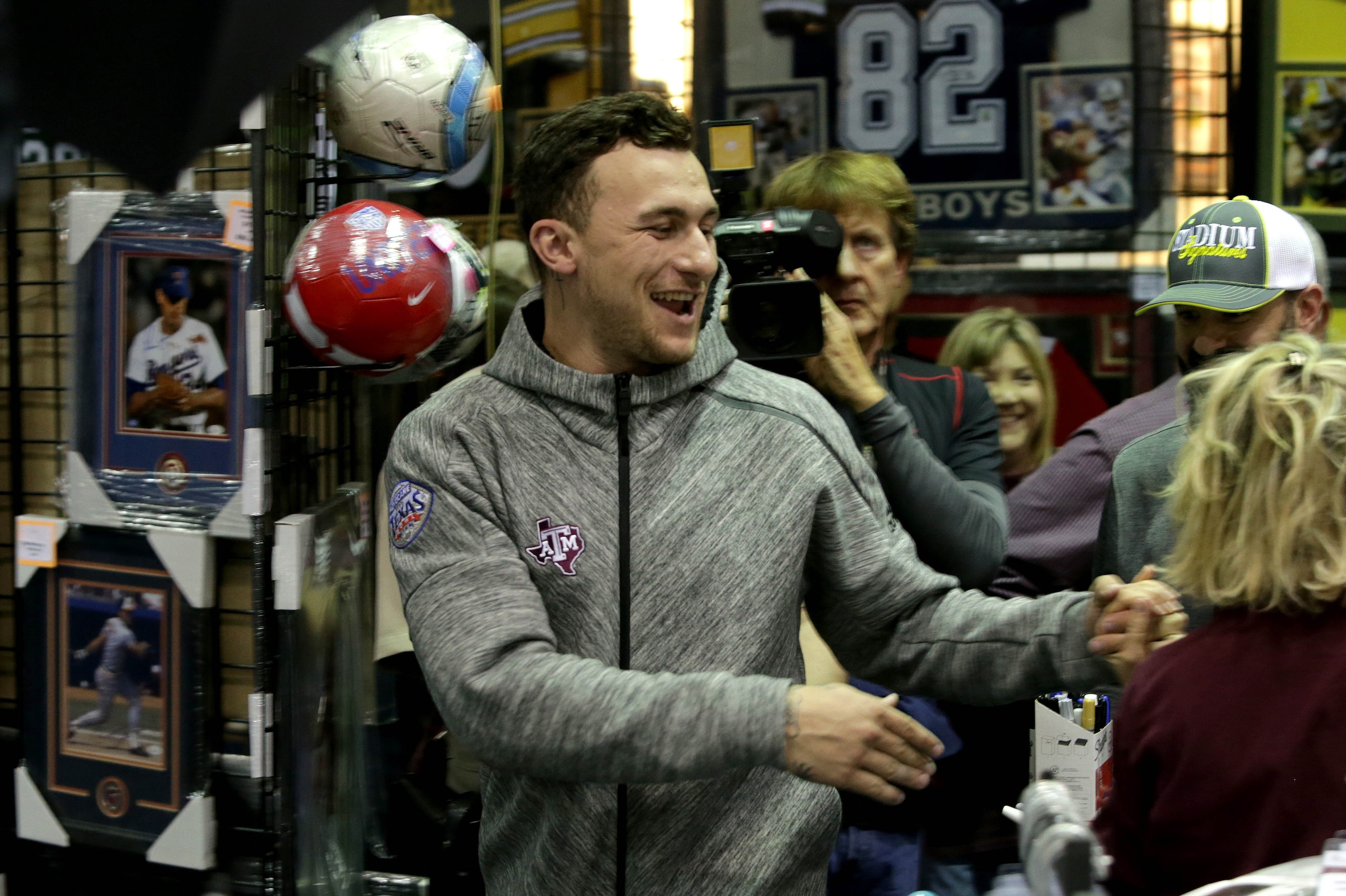 Feb 2, 2017; Katy, TX, USA; Sherry Collins, of Waco, Texas and former Texas A&M quarterback and 2012 Heisman Trophy winner Johnny Manziel have fun talking with each other as Manziel walked out for a portrait session inside Stadium Signatures inside the Ka