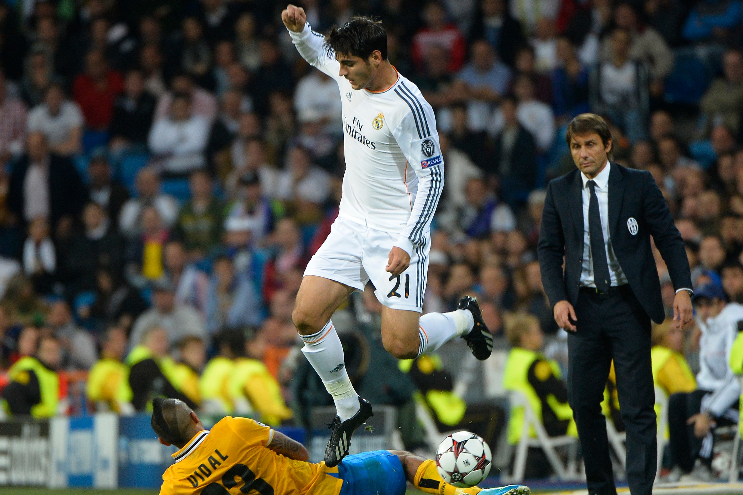 Real Madrid's forward Alvaro Morata (top) vies with Juventus' Chilean midfielder Arturo Erasmo Pardo Vidal (L) near to Juventus' coach Antonio Conte (R) during the UEFA Champions League Group B football match Real Madrid CF vs Juventus at the Santiago Ber Real Madrid's forward Alvaro Morata (top) vies with Juventus' Chilean midfielder Arturo Erasmo Pardo Vidal (L) near to Juventus' coach Antonio Conte (R) during the UEFA Champions League Group B football match Real Madrid CF vs Juventus at the Santiago Ber