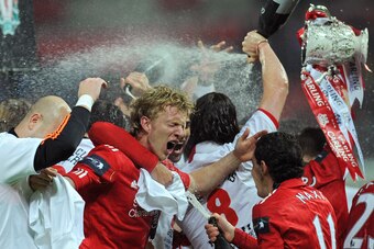 Liverpool's Dutch footballer Dirk Kuyt (2nd L) is doused in champagne as his team celebrate beating Cardiff City in a penalty shoot out in the League Cup Final at Wembley Stadium in London, on February 26, 2012. AFP PHOTO/ADRIAN DENNIS
RESTRICTED TO EDITO