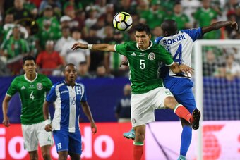 Mexico's Jesus Molina (2nd R) heads the ball beside Oscar Boniek Garcia from Honduras (R)  in their quarter final game during the 2017 CONCACAF Gold Cup at the University of Phoenix Stadium on July 20, 2017. / AFP PHOTO / MARK RALSTON        (Photo credit