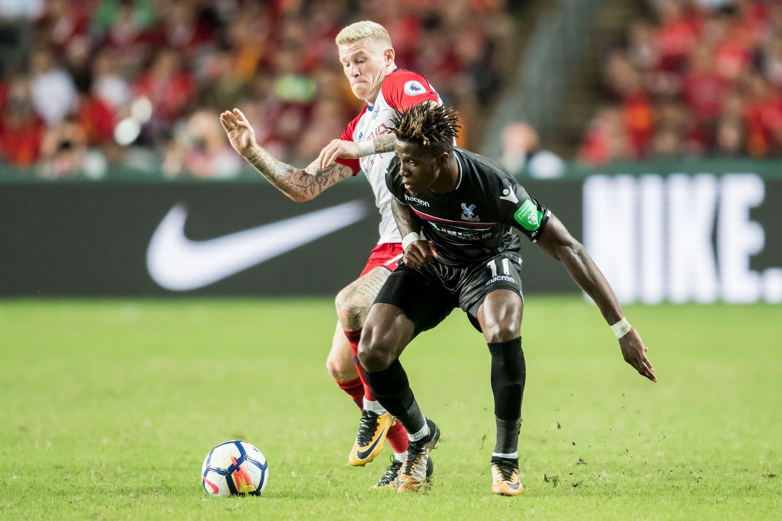 HONG KONG, HONG KONG - JULY 22: Crystal Palace midfielder Wilfried Zaha (R) fights for the ball with West Bromwich Albion midfielder James McClean  during the Premier League Asia Trophy match between West Brom and Crystal Palace at Hong Kong Stadium on Ju