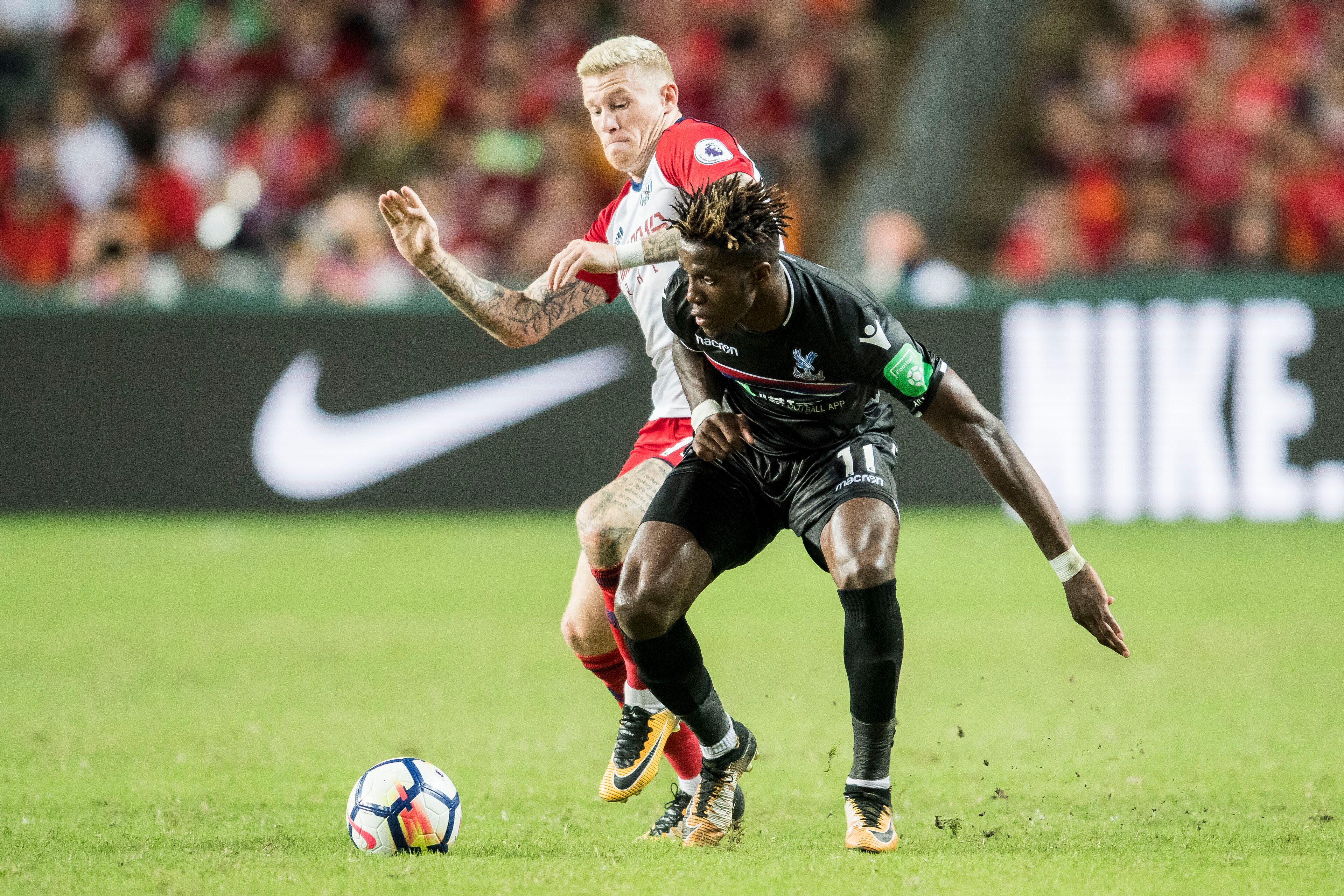 HONG KONG, HONG KONG - JULY 22: Crystal Palace midfielder Wilfried Zaha (R) fights for the ball with West Bromwich Albion midfielder James McClean  during the Premier League Asia Trophy match between West Brom and Crystal Palace at Hong Kong Stadium on Ju