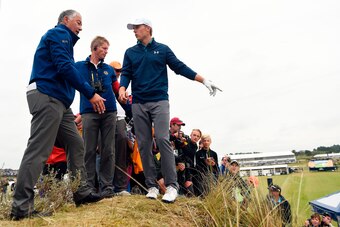 US golfer Jordan Spieth (C) discusses his options with a rules official after taking a penalty drop for having an unplayable lie on the 13th hole during his final round on day four of the 2017 Open Golf Championship at Royal Birkdale golf course near Sout