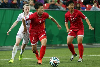 TORONTO, ON - AUGUST 16:  Choe Sol Gyong of Korea DPR gets past Rose Lavelle of the United States during the FIFA U-20 Women's World Cup Canada 2014 Quarter Final match between Korea DPR and the United States at the National Soccer Stadium on August 16, 2