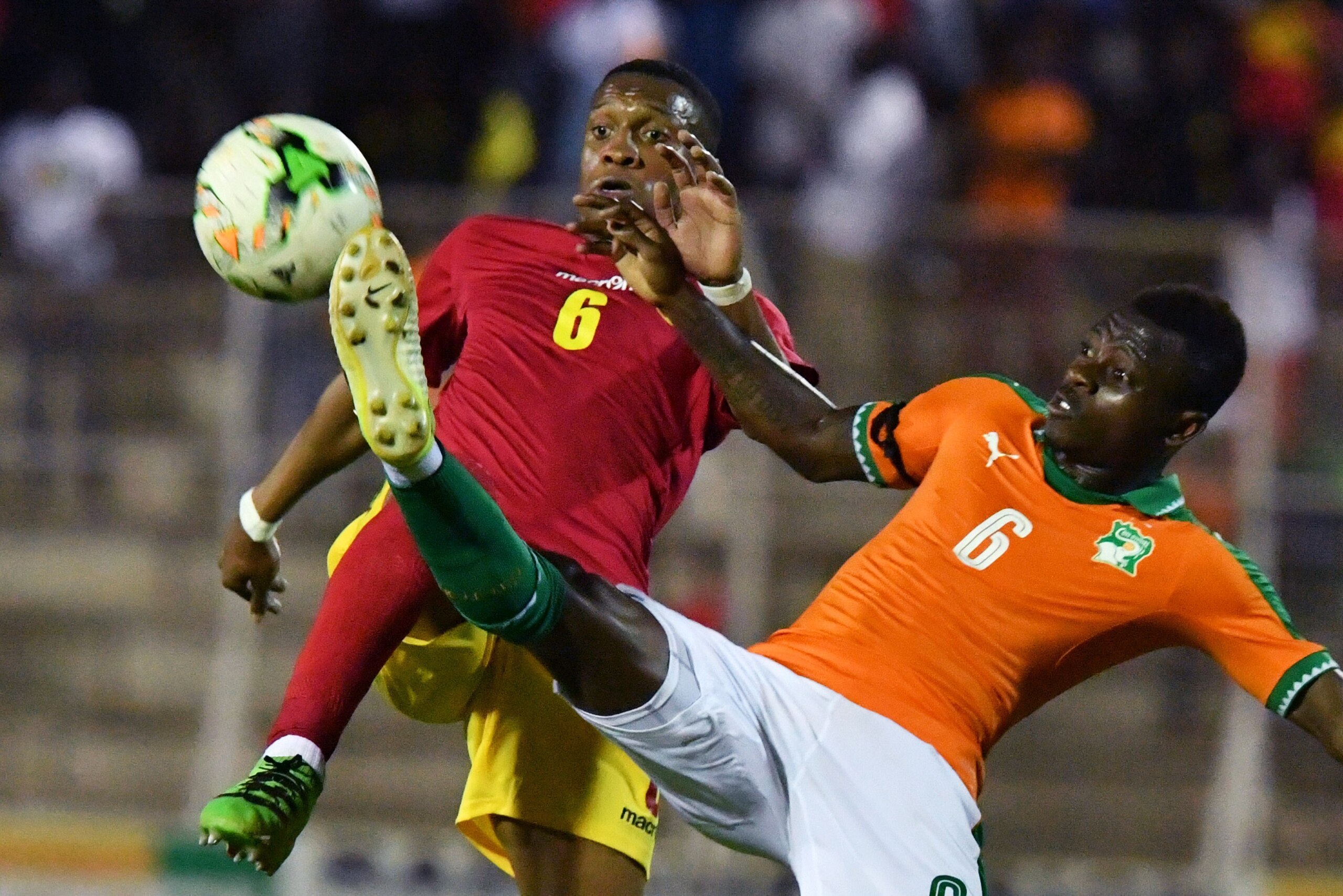 Ivory Coast's Jean Michael Seri (R) fights for the ball with Guinea's Ousmane Balde (L)  during the 2019 Africa Cup of Nations qualifying football match between Ivory Coast and Guinea at the Stade de la Paix in Bouake, on June 10, 2017. / AFP PHOTO / ISSO