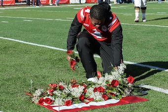 LINCOLN, NE - NOVEMBER 19: Quarterback Tommy Armstrong Jr. #4 of the Nebraska Cornhuskers places a rose in memory of deceased player Sam Foltz before the game against the Maryland Terrapins at Memorial Stadium on November 19, 2016 in Lincoln, Nebraska. (P